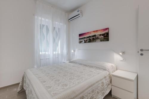 una camera bianca con un letto e una finestra di Trastevere Design Apartment a Roma