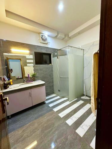a bathroom with a shower and a sink and a mirror at AAA Guest House in Rawalpindi