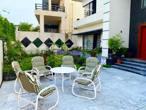 a group of chairs and a white table and chairs at AAA Guest House in Rawalpindi