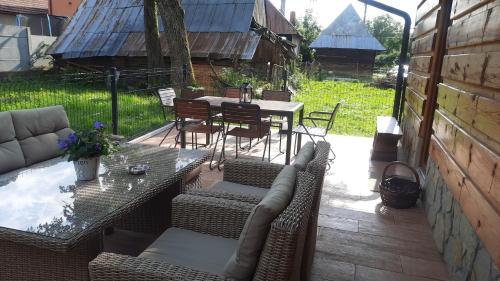 a patio with a couch and a table and chairs at Penzion a drevenica pri Hati in Terchová