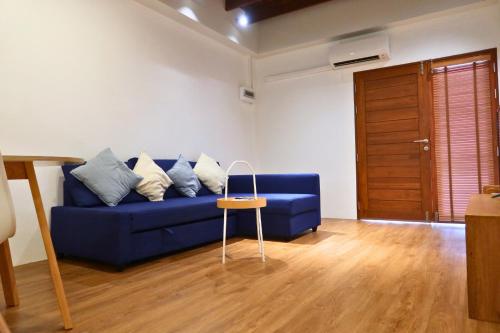 a blue couch in a living room with a wooden floor at Entire house in Chiang Mai downtown - Northern Nest in Chiang Mai