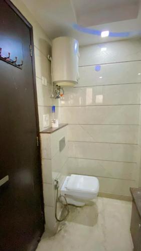 a bathroom with a white toilet in a room at Cassava Stay in New Delhi