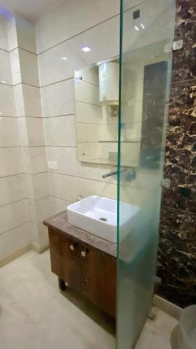 a bathroom with a sink and a glass shower at Cassava Stay in New Delhi