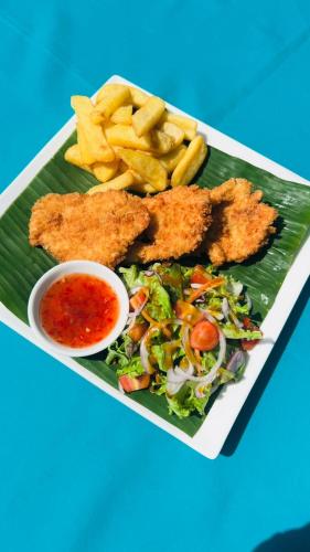 a plate of food with fish and a salad and french fries at Baan Kiao in Haad Yao