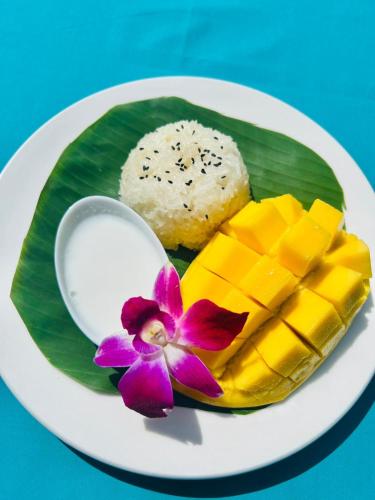 a plate of food with mangoes and a spoon on a banana leaf at Baan Kiao in Haad Yao