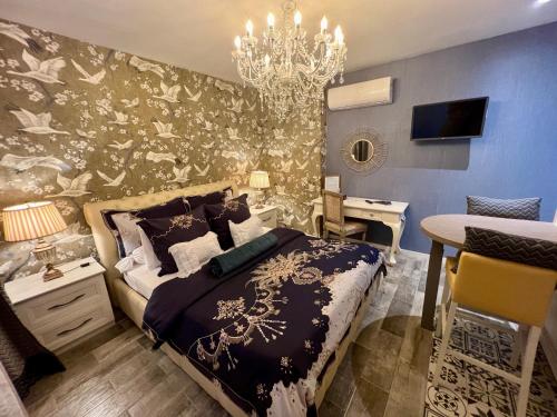 a bedroom with a bed and a chandelier at La Casa dei Sogni in Flayosc