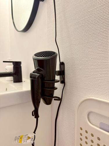 a hair dryer hanging on a wall next to a sink at 1日1組限定 森の中の貸切コテージundo in Narusawa