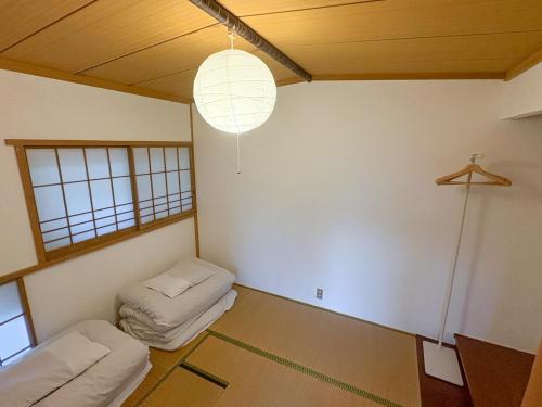 a room with two beds and a light fixture at 1日1組限定 森の中の貸切コテージundo in Narusawa