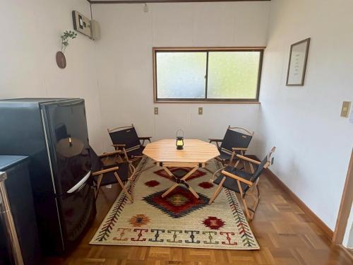 a room with a table and chairs and a window at 1日1組限定 森の中の貸切コテージundo in Narusawa