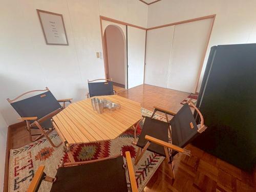 a dining room with a wooden table and chairs at 1日1組限定 森の中の貸切コテージundo in Narusawa