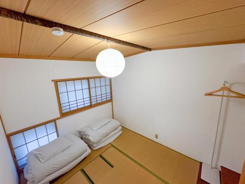 a room with two beds in the corner of a room at 1日1組限定 森の中の貸切コテージundo in Narusawa