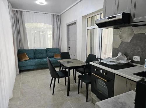 a kitchen and a living room with a table and chairs at Коттедж в ЦО Радуга на Исык-Куле in Cholpon-Ata