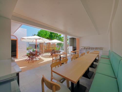 a dining room with tables and chairs and a patio at Avenly Omadhoo in Omadhoo