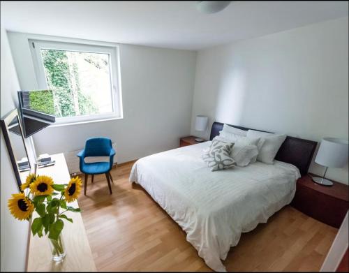 a bedroom with a bed and a vase of sunflowers on the floor at Montreux Stunning 2 Bedroom Apartment Lake Geneva in Montreux