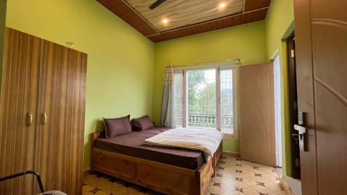 Un dormitorio con una cama en una habitación con ventana. en Hotel Maa Bhagwati Sweet And Restaurant, en Almora