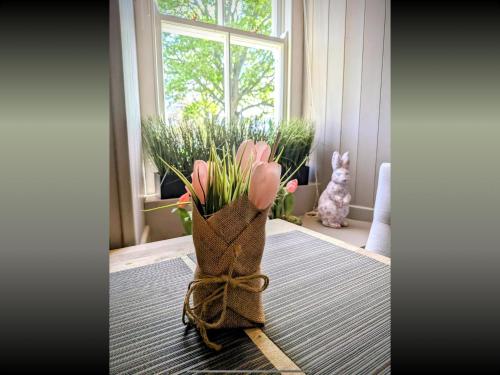 a vase filled with pink tulips sitting on a table at Bird In Bush Elsdon in Elsdon