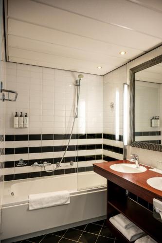 a bathroom with a tub and a sink and a shower at Crowne Plaza Maastricht by IHG in Maastricht