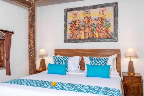 a bedroom with a bed with blue and white pillows at Clamonic Villa Ubud - Monthly Rental Available in Sukawati
