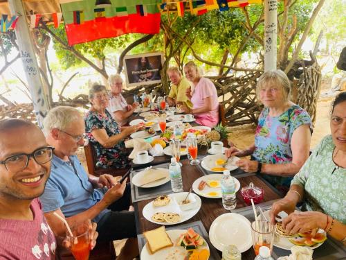 a group of people sitting at a table eating food at Beach Bungalow Yala in Kirinda