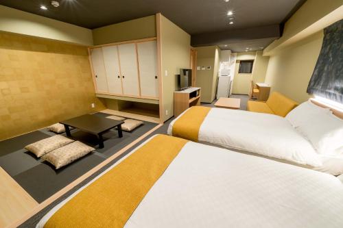 a hotel room with two beds and a table at RESI STAY ANDON in Kyoto