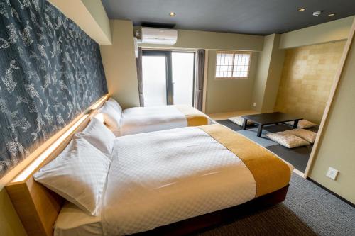a hotel room with two beds and a window at RESI STAY ANDON in Kyoto