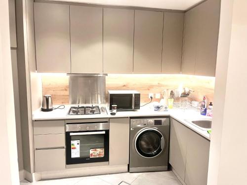 a kitchen with a stove and a washing machine at The Damac apartment in Amman