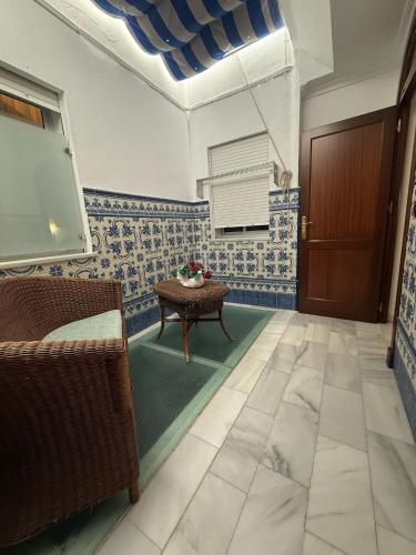 a living room with a table and a door at Hotel La Española in Chipiona