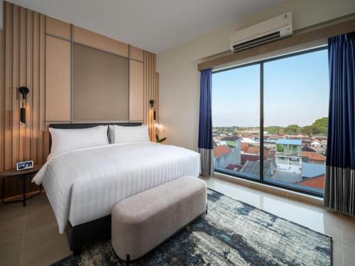 Una cama o camas en una habitación de Aston Inn Lumajang - East Java