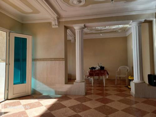 une pièce avec une table et des colonnes et une table et des chaises dans l'établissement appart en front de mer, à Mostaganem