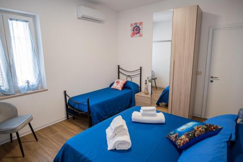 - 2 lits dans une chambre avec des draps bleus dans l'établissement Riserva-La marea, à Vasto