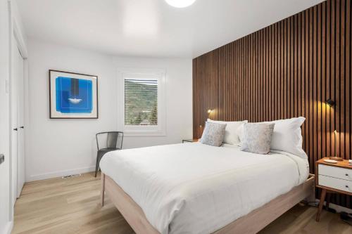 a bedroom with a large white bed and a window at Shadow Mountain 20 in Aspen