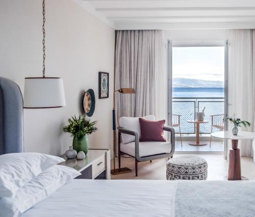a bedroom with a bed and a chair and a balcony at Amadria Park Grand Hotel 4 Opatijska Cvijeta in Opatija