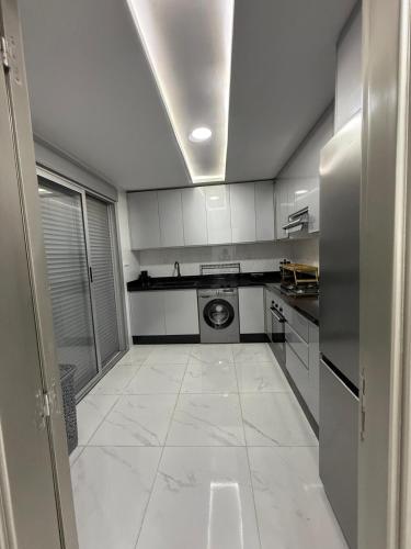a large white kitchen with a washer and dryer at Appart Résidence Sabrin in Fnidek