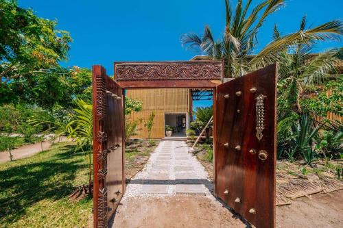 an entrance to a house with a wooden door at 1 BDR Garden Apartment at The Soul, Paje in Paje
