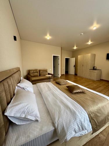 a large bedroom with a large bed with white sheets at MARCO Hotel in Goris
