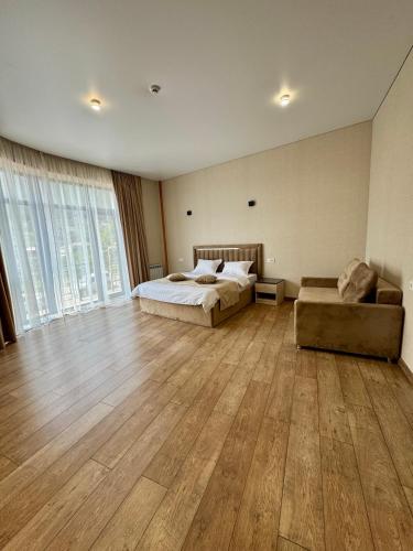 a large bedroom with a bed and a couch at MARCO Hotel in Goris