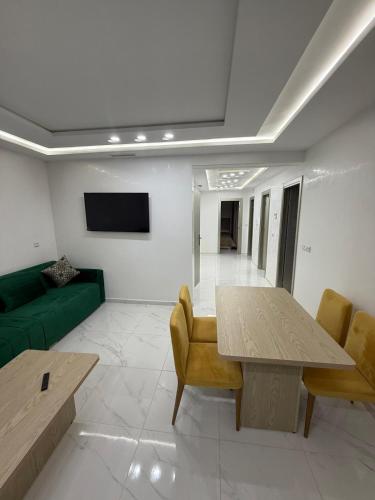 a living room with a green couch and a table at Appart Résidence Sabrin in Fnidek
