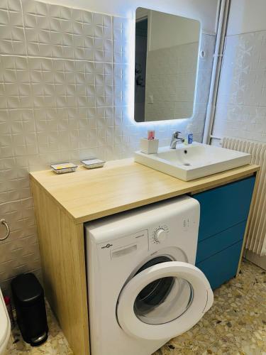 une salle de bain avec une machine à laver et un lavabo dans l'établissement T1 Ensoleillé avec Balcon Mourillon Plages, Toulon, à Toulon
