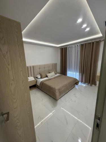 a bedroom with a bed in the middle of a room at Appart Résidence Sabrin in Fnidek