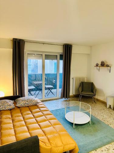 un salon avec un lit et une table en verre dans l'établissement T1 Ensoleillé avec Balcon Mourillon Plages, Toulon, à Toulon