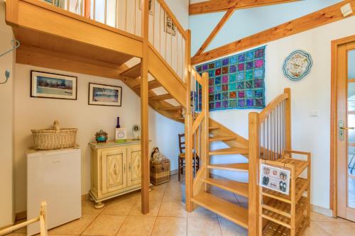 a wooden staircase in a room with white walls at La Palmeraie - Chambre Musique in Portiragnes