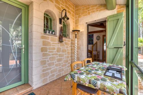 a patio with a table and a green door at La Palmeraie - Chambre Musique in Portiragnes