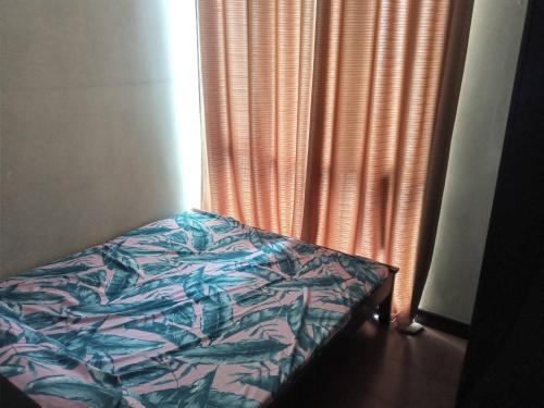 a bedroom with a bed and a window with curtains at Condo staycation in SLP Bangkal Makati in Manila