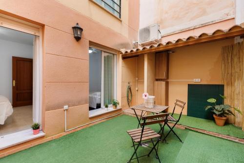 a patio with a table and chairs on a balcony at Home Trinidad in Málaga