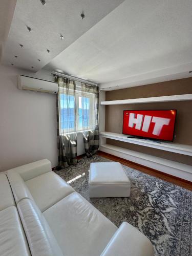a living room with a white couch and a tv at Esprit D'Hotel Panoramico in Fonteno