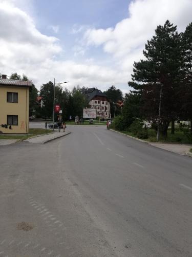 une rue déserte avec un bâtiment au loin dans l'établissement Frajla, à Zlatibor