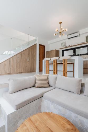 a living room with a couch and a staircase at Charming 1BR Villa with Pool and Wooden Interior in Cemagi