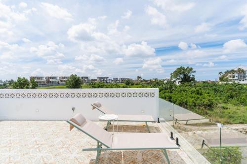 a patio with a bench and a table on a white wall at Charming 1BR Villa with Pool and Wooden Interior in Cemagi