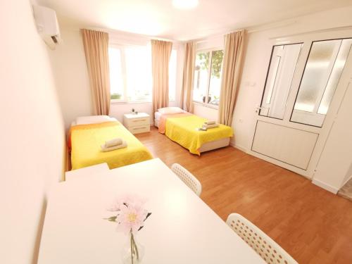 a room with a dining table and a bedroom at Studio Garden City Center Pomorie in Pomorie