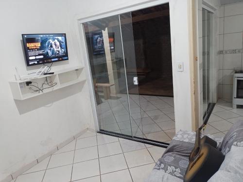 bagno con doccia in vetro e TV a parete di Iporã casa simples Ar-cond, wi-fi, smartv, máquina de lavar 6 pessoas, equipado com churrasqueira, garagem para 4 carros sendo 2 coberta, Hop Independente ad Araçatuba